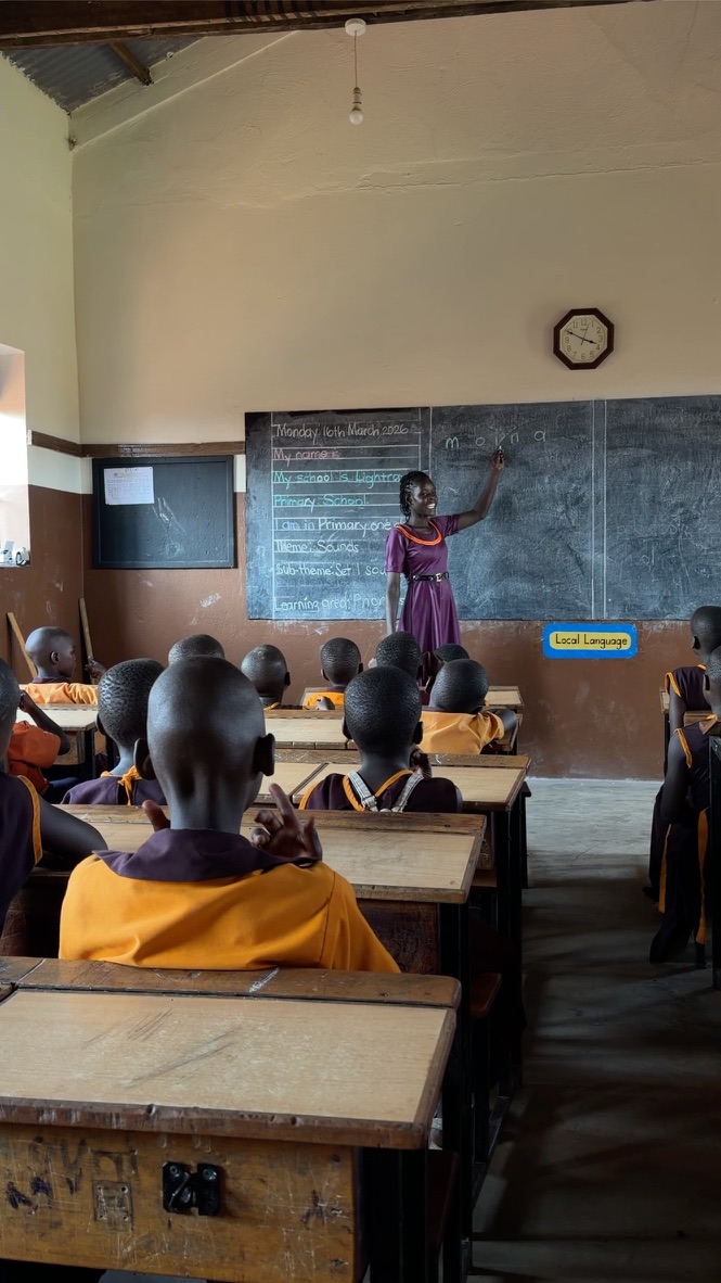 Lehrerin mit ernstem Blick im lila Kleid, Kreidetafel, Uhr, Klasse in Orange