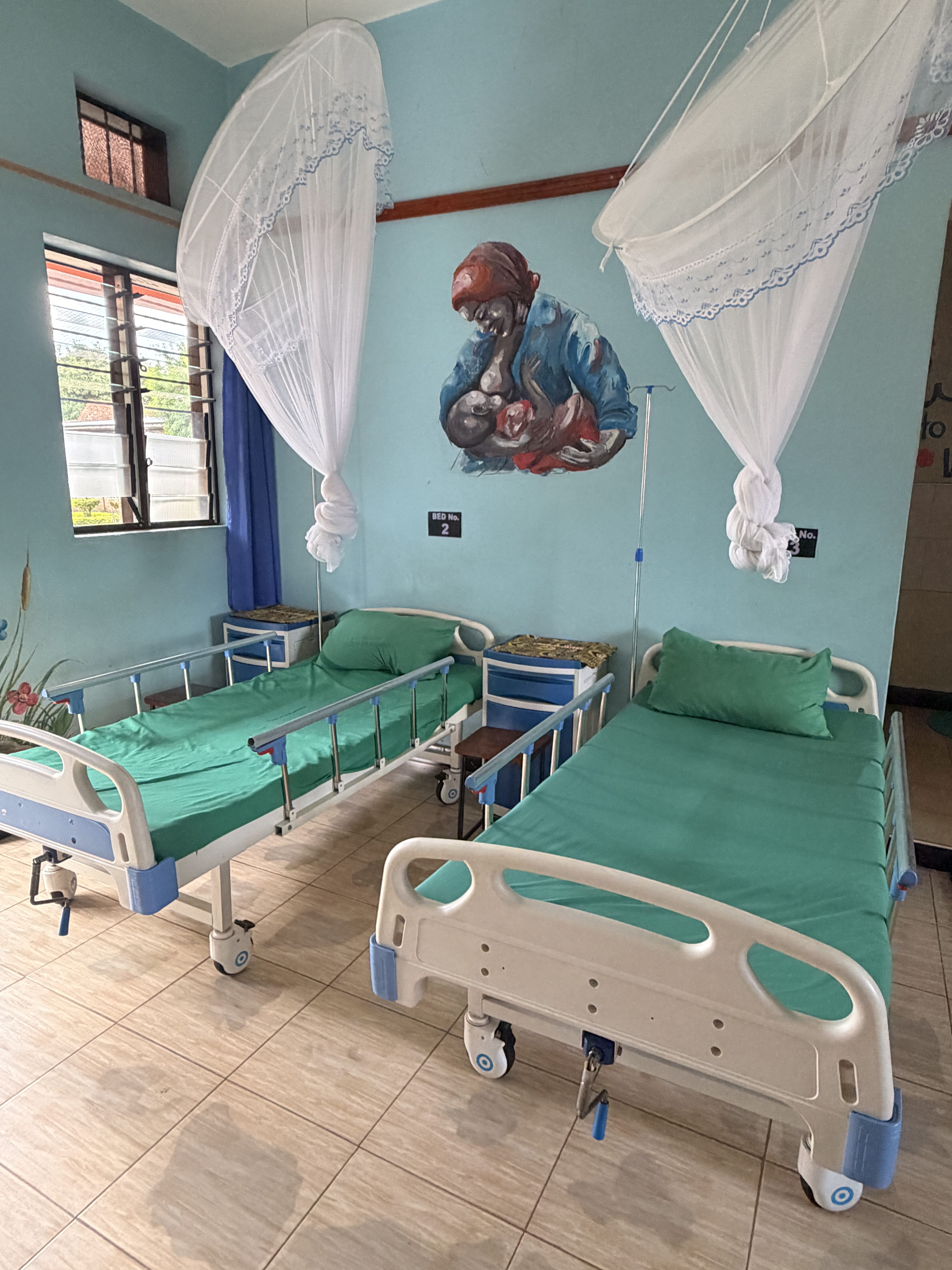 Zwei leere Krankenhausbetten mit grüner Bettwäsche und weißen Netzen, ruhige Stimmung